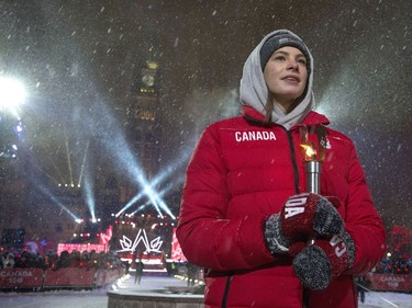 Olympic swimming gold medallist Penny Oleksiak holds a Fire of Friendship Relay torch during a celebration on Parliament Hill.