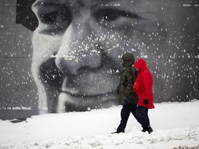 People walk past the Sir Winston Churchill mural on Churchill Avenue as Ottawa gets another winter storm Saturday December 31, 2016.