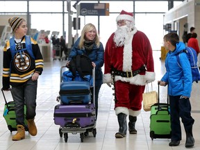 Renee Dorion couldn't help but laugh as Santa caught up with her and her sons, Dominic, 13, and Benjamin, 10, as they made their way to the departure desk at the Ottawa airport Friday (Dec. 23, 2016)  -  one of the busiest travel days of the year. The family were en route to Moncton, New Brunswick to spend Xmas with family Friday. Julie Oliver/Postmedia