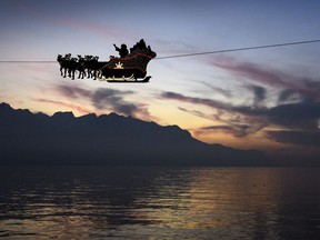 Santa Claus waves to the crowd from his flying sleigh drawn by reindeer.