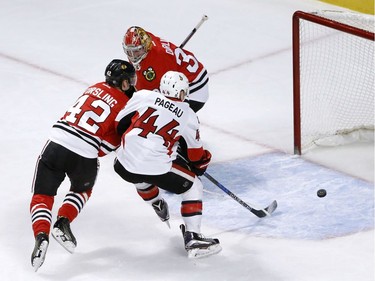 Chicago Blackhawks' Gustav Forsling (42) keeps Ottawa Senators' Jean-Gabriel Pageau (44) from getting a shot on goal as Scott Darling defends during the first period of an NHL hockey game, Tuesday, Dec. 20, 2016, in Chicago.