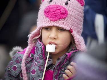 Genevieve Bernie, 7, takes a bite of her roasted marshmallow.