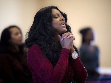 The congregation at a Bible Way Ministries service on Sunday remembered two teenage sisters killed in a crash Friday. Charlene Carnegie, a friend of the Muzaliwa family, prays with her hands clasped during Sunday's service.