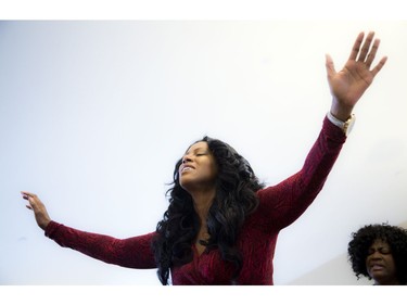 Carlene Carnegie, a friend of the Muzaliwa family, raises her hands while she sings and dances along with the congregation.