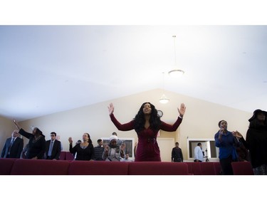 The congregation at a Bible Way Ministries service on Sunday remembered two teenage sisters killed in a crash Friday. Carlene Carnegie, a friend of the Muzaliwa family, raises her hands while she sang along with the congregation.