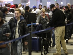 CHICAGO, IL - DECEMBER 23 : A member of Homeland Security walks with his K-9 dog as travelers wait in the TSA security line at O'Hare International Airport on December 23, 2016 in Chicago, Illinois.