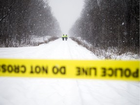 Members of Ottawa Police's Emergency Services Unit walk down the train line that crosses McCarthy Road Saturday morning looking for evidence from the Friday night double-homicide of sisters Nasiba and Asma A-Noor. Their brother, Musab, has been charged with first- and second-degree murder.