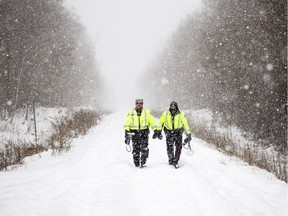 Members of Ottawa Police's Emergency Services Unit walk down the train line that crosses McCarthy Road looking for evidence from the double homicide of sisters Nasiba and Asma A-Noor.