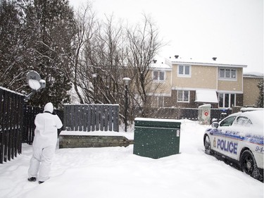 A member of Ottawa Police's Forensic Identification Section photographs the scene Saturday morning.