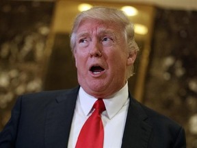 In this Jan. 13, 2017, photo, President-elect Donald Trump speaks with reporters in the lobby of Trump Tower in New York. Trump‚Äôs meetings this week with CEOs seeking federal approval for major mergers are raising red flags for ethics lawyers concerned that about the possible erosion of a firewall between the regulators tasked with approving the billion-dollar deals and the White House. (AP Photo/Evan Vucci)