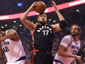 Toronto Raptors center Jonas Valanciunas (17) grabs a rebound as New York Knicks forward Lance Thomas (42) and center Joakim Noah (13) look on during first half NBA basketball action in Toronto on Sunday, January 15, 2017.