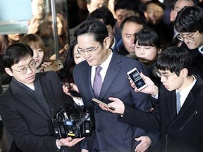 Lee Jae-yong, center, a vice chairman of Samsung Electronics Co. is questioned by reporters upon his arrival at the Seoul Central District Court in Seoul, South Korea, for a hearing Wednesday, Jan. 18, 2017. The Seoul Central District Court will decide whether to arrest Lee after prosecutors requested the arrest earlier this week. (AP Photo/Lee Jin-man)