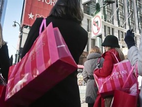 FILE - In this Saturday, Nov. 23, 2013, file photo, shoppers carry Victoria Secret bags while crossing an intersection in Herald Square in New York. The Associated Press looks at ways to erase credit card balances from your holiday spending, plus ways to rethink your approach so the next round of holiday spending is manageable. (AP Photo/Bebeto Matthews, File)