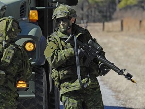 This file photo from February 2013 shows Private Jason Mullins (right) and Corporal Crystal McDonald (left) both from 36 Service Battalion, guarding a convoy while on exercise in the U.S. Photo : Master Corporal David McCord, Army Public Affairs, Land Force Atlantic Area, Halifax, © 2013 DND-MDN Canada