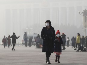 A foreign tourist and a child wearing protection masks walk through Tiananmen Square in Beijing as the capital of China is blanked by heavy smog on Wednesday, Jan. 4, 2017. China has long faced some of the worst air pollution in the world, blamed on its reliance of coal for energy and factory production, as well as a surplus of older, less efficient cars on its roads. Inadequate controls on industry and lax enforcement of standards have worsened the pollution problem.