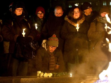 - A man lays flowers and bows his head in prayer for the victims around the eternal flame as others hold candles. More than 1,000 people came out to a candlelight vigil for the victims of the Quebec mosque attack Monday (Jan. 30, 2017) in front of Parliament Hill's eternal flame. Julie Oliver/Postmedia