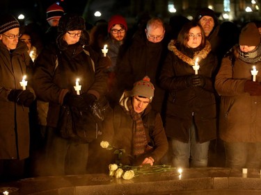- A man lays flowers for the victims around the eternal flame as others hold candles. More than 1,000 people came out to a candlelight vigil for the victims of the Quebec mosque attack Monday (Jan. 30, 2017) in front of Parliament Hill's eternal flame. Julie Oliver/Postmedia