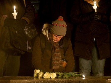 - A man lays white roses and bows his head in prayer for the victims. More than 1,000 people came out to a candlelight vigil for the victims of the Quebec mosque attack Monday (Jan. 30, 2017) in front of Parliament Hill's eternal flame. Julie Oliver/Postmedia