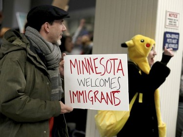 Adrian Hegeman, of St. Paul, holds a sign while joining other protesters at the Minneapolis-St. Paul International Airport.