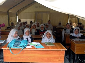 Afghan schoolgirls sit in a tent as they attend class in Kandahar, Afghanistan, in 2014.
