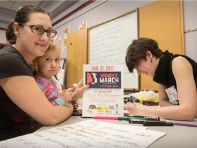 Amanda Carver and her three-year-old daughter Sylvia work on placards for the Ottawa march.