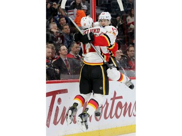 Calgary's Johnny Gaudreau (right) jumps in the arms of his elated teammate Mikael Backlund after scoring the overtime goal to win 3-2 with 30 seconds left against the Ottawa Senators at Canadian Tire Centre Thursday (Jan. 26, 2017).  Julie Oliver/Postmedia