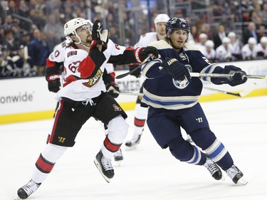 Ottawa Senators' Erik Karlsson, left, of Sweden, and Columbus Blue Jackets' Brandon Saad look up for the puck during the second period of an NHL hockey game Thursday, Jan. 19, 2017, in Columbus, Ohio.