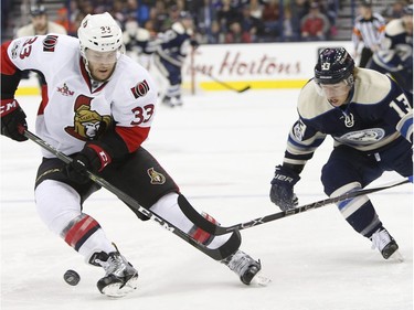 Ottawa Senators' Fredrik Claesson, left, of Sweden, knocks the puck away from Columbus Blue Jackets' Cam Atkinson during the second period of an NHL hockey game Thursday, Jan. 19, 2017, in Columbus, Ohio.