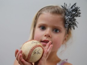 Georgia Kate Riggs, almost 6 years old, holds a baseball with Tim Raines' autograph.