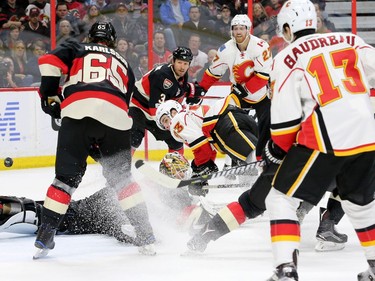 In mid air, Calgary's Sean Monahan, along with Ottawa goalie Mike Condon, eye the puck heading into the net during second-period action between the Ottawa Senators and Calgary Flames at Canadian Tire Centre Thursday (Jan. 26, 2017). The Flames were ahead 2-0 at the end of the period. Julie Oliver/Postmedia