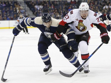 Columbus Blue Jackets' Jack Johnson, left, and Ottawa Senators' Curtis Lazar chase the puck during the first period of an NHL hockey game Thursday, Jan. 19, 2017, in Columbus, Ohio.