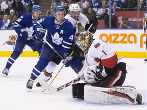 Ottawa Senators goalie Mike Condon makes a save as the Toronto Maple Leafs' Leo Komarov and the Senators' Cody Ceci skate in during the second period in Toronto on Saturday, Jan. 21, 2017.