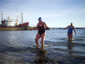 Diane Harper, left, and Nadine Bennett make their way back to shore after their chilling swim in the St. Lawrence.