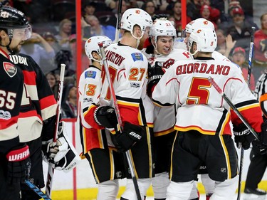 As Erik Karlsson looks on, Calgary Sean Monahan gets congratulated by his teammates following his goal during second-period action between the Ottawa Senators and Calgary Flames at Canadian Tire Centre Thursday (Jan. 26, 2017). The Flames were ahead 2-0 at the end of the period. Julie Oliver/Postmedia