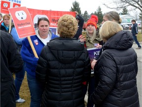 Ontario Premier Kathleen Wynne, centre, talks with Hydro One protesters outside the Fanshawe College Aviation Centre in London, Ontario on Tuesday January 24, 2017 .  MORRIS LAMONT/THE LONDON FREE PRESS /POSTMEDIA NETWORK