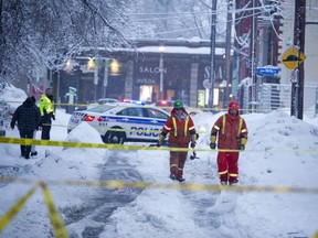 Ottawa Police shut down part of O'Connor and Lewis streets due to power lines falling with the winter storm that hit the area. Hydro Ottawa employees walk down Lewis Street assessing the active lines.   Photos by Ashley Fraser/Postmedia