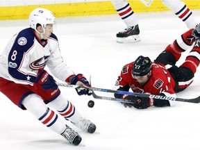 Ottawa Senators' Curtis Lazar (27) dives for the puck as Columbus Blue Jackets' Zach Werenski (8) reacts during first period NHL hockey action in Ottawa on, Sunday January 22, 2017.