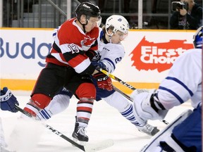 Ottawa's Artur Tyanulin wrestles for the puck with Mississauga's Jacob Moverare  in front of Mississauga's net during first-period action between the Ottawa 67s (red) and the Mississauga Steelheads at TD Place Tuesday (Jan. 24, 2017) evening.