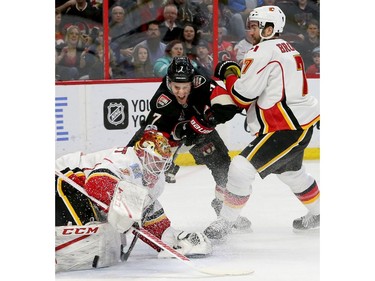 Ottawa's Kyle Turris battles TJ Brodie as the puck skids under Calgary goalie Brian Elliot's glove during first-period action between the Ottawa Senators and Calgary Flames at Canadian Tire Centre Thursday (Jan. 26, 2017). Julie Oliver/Postmedia