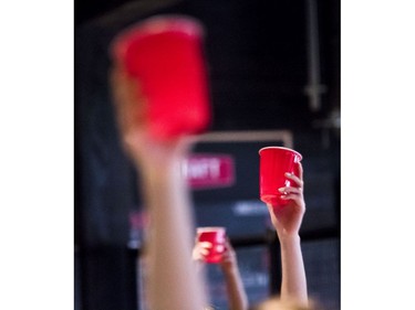 Participants raise red cups during beer yoga class.