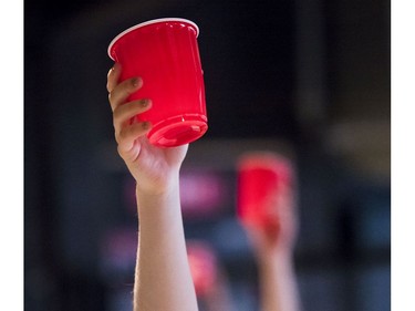 Participants raise red cups during beer yoga class.