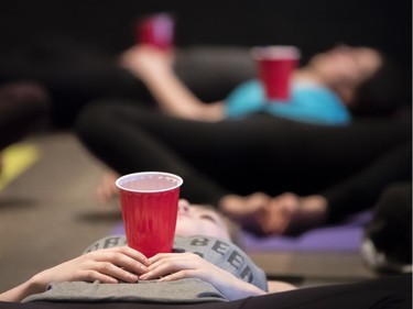 Participants relax with red cups during a Yoga On Tap "beer yoga" class at the Craft Beer Market in Ottawa on Saturday, Jan. 21, 2017. Due to the timing of this class, beer was consumed after legal serving hours began.