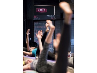 Participants stretch during a beer yoga class at the Craft Beer Market.