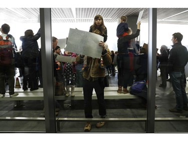 A demonstrator makes a sign during a rally against a ban on Muslim immigration at San Francisco International Airport.