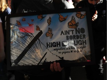 A demonstrator holds a plaque during a rally against a ban on Muslim immigration at San Francisco International Airport.