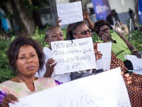 A woman holds a placard that reads "Our lives are worth more than your personal interests" at a December rally protesting President Joseph Kabila's refusal to step down at the end of his mandate.