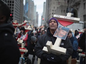 CHICAGO, IL - DECEMBER 31: Erich Lewis carries a cross bearing the name of his friend as he marches with other residents, activists and family members of victims of gun violence down Michigan Avenue to draw attention to t he city's rising murder rate on December 31, 2016 in Chicago, Illinois. Nearly 800 people have been murdered in the city this year and more than 4000 shot as the city copes with its most violent year in two decades.