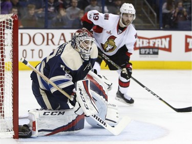 Columbus Blue Jackets' Sergei Bobrovsky, left, of Russia, protects the net as Ottawa Senators' Derick Brassard looks for the puck during the first period of an NHL hockey game Thursday, Jan. 19, 2017, in Columbus, Ohio.