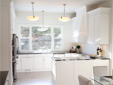 The old art deco kitchen has been renovated to include granite countertops, white iron double sinks and stone floors. The original light fixtures still shine brightly.