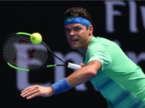 Milos Raonic of Canada hits a return against Dustin Brown of Germany during their men's singles match on day two of the Australian Open tennis tournament in Melbourne on January 17, 2017.